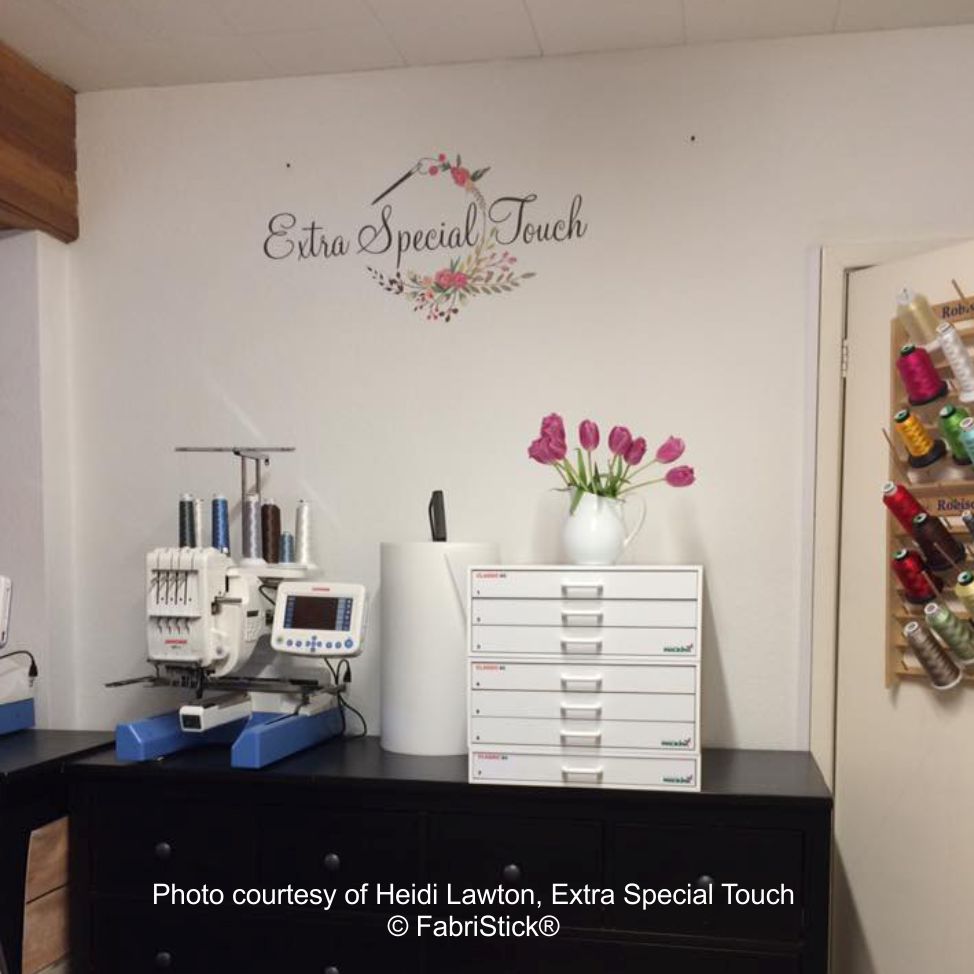 Embroidery machine and supplies on a desk with 'Extra Special Touch' branding.
