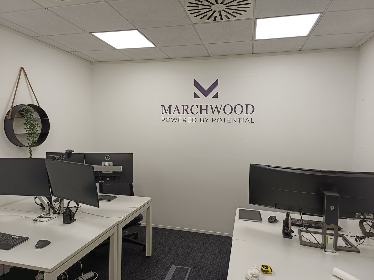 Modern office setup with desks, computers, and Marchwood logo on the wall.