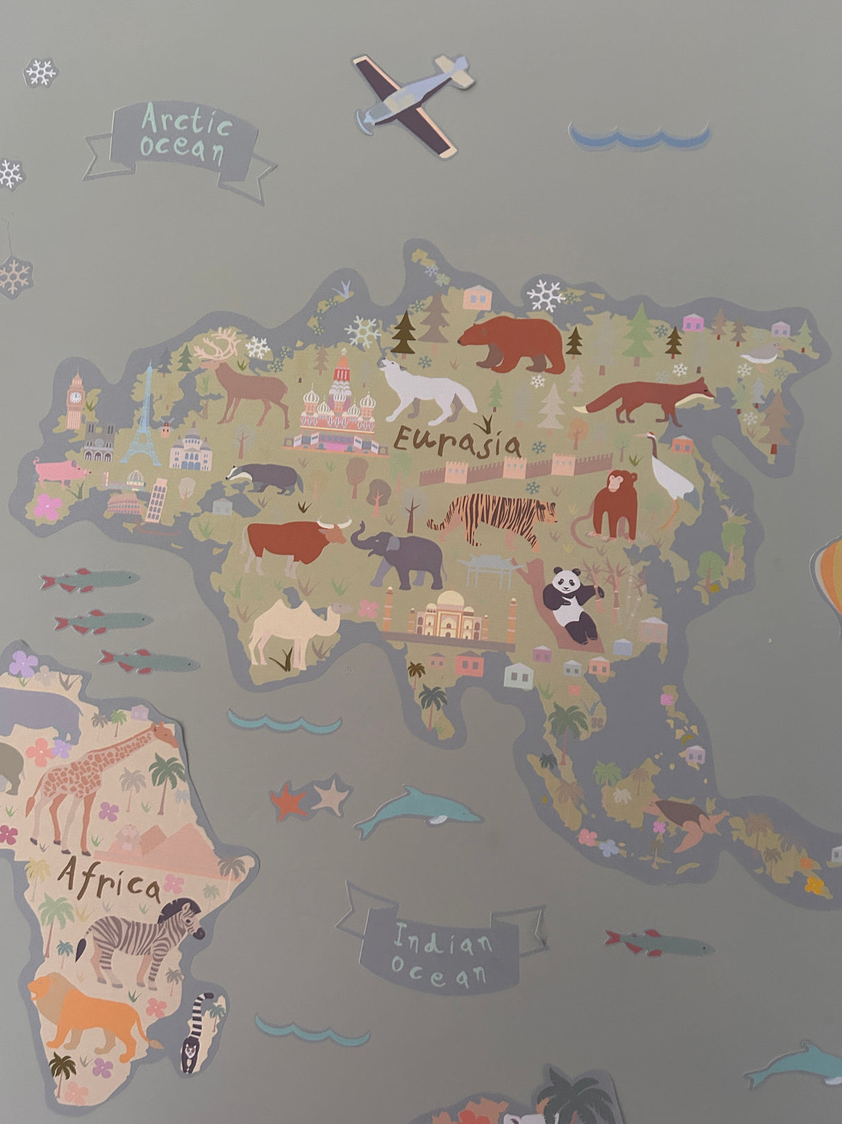 Children's map of the world with animal illustrations on a gray background