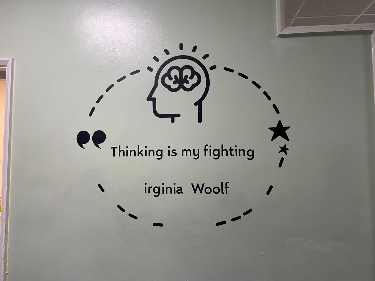 Wall decal with a brain illustration and quote by Virginia Woolf on a light gray wall.