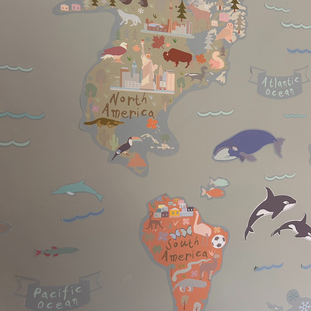 Map of North and South America with animals and landmarks on a gray background