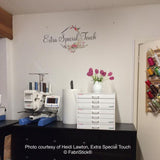 Embroidery machine and supplies on a desk with 'Extra Special Touch' branding.