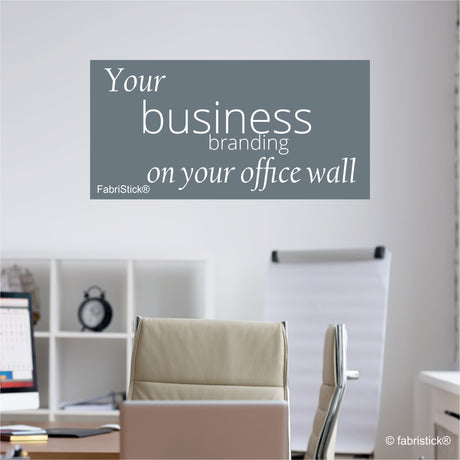 Office setting with a wall decal promoting 'Your business branding on your office wall' by FabriStick.