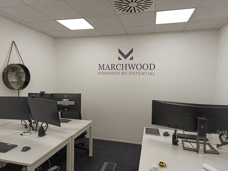 Modern office setup with desks, computers, and Marchwood logo on the wall.
