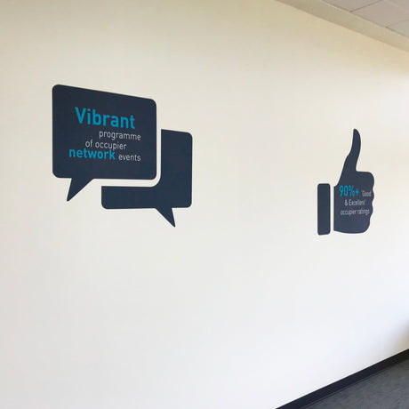 Decorative wall decal with speech bubbles and a thumbs-up icon on a white wall.