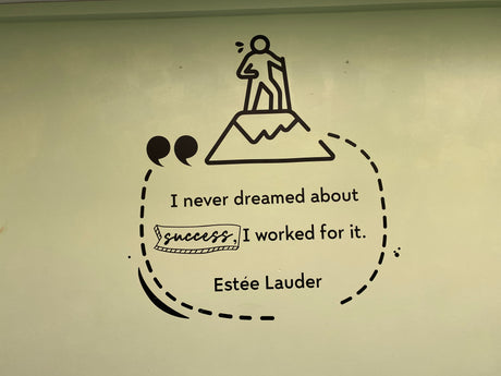 Motivational quote from Estée Lauder with a silhouette of a person on top of a mountain.