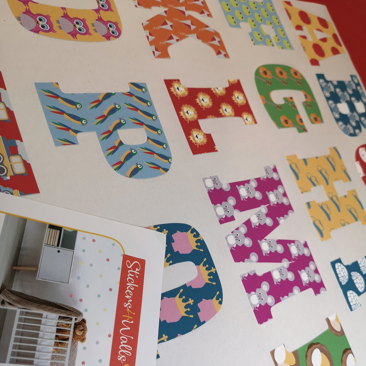 Colorful alphabet letters on a white surface with a 'Stickers on Walls' product card.