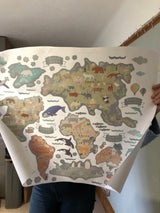 Person holding a large world map with animal illustrations