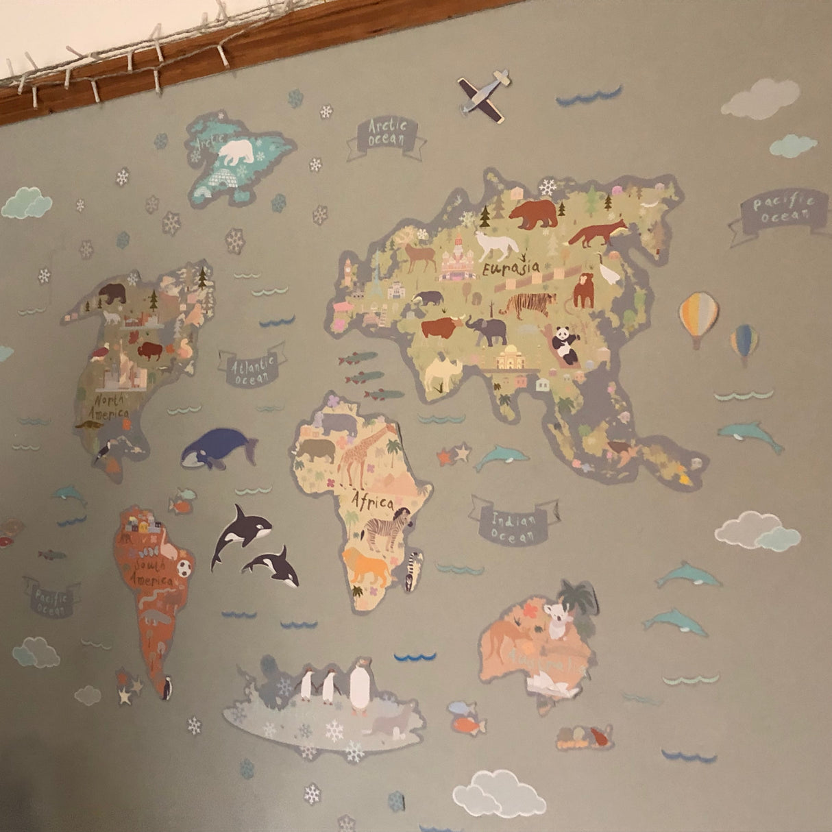 World map with animal illustrations on a gray wall